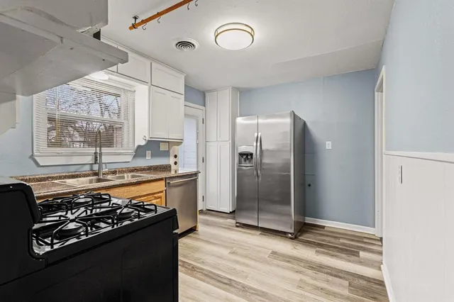a kitchen with stainless steel appliances granite countertop a stove and a refrigerator
