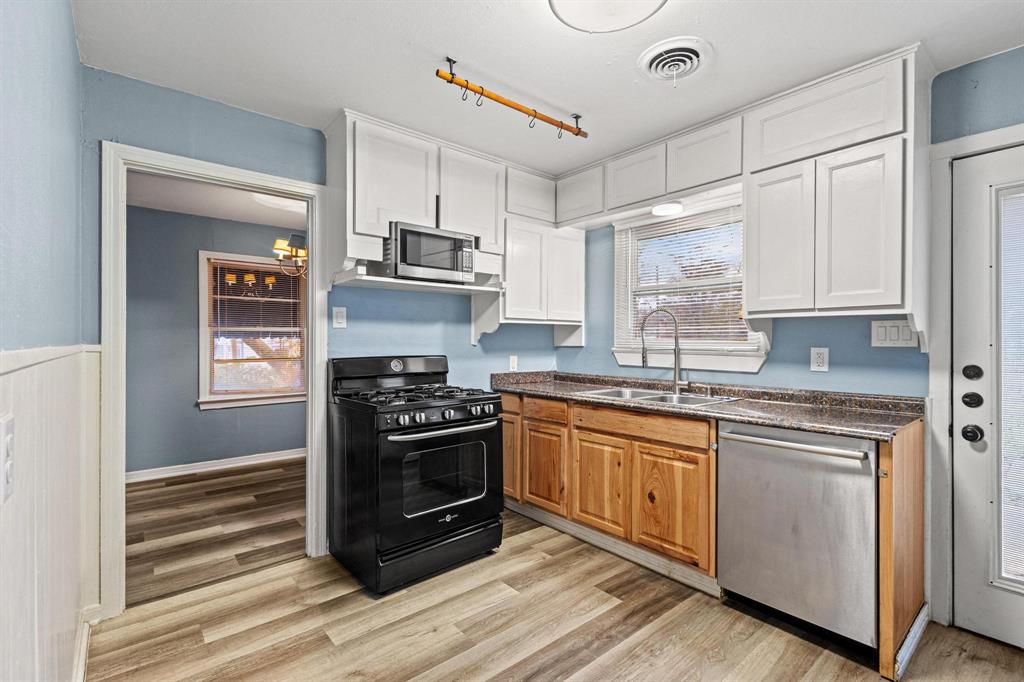 531 West Bullock Street Denison, TX 75020 - Photo 12 of 28 a kitchen with stainless steel appliances granite countertop a stove and a refrigerator