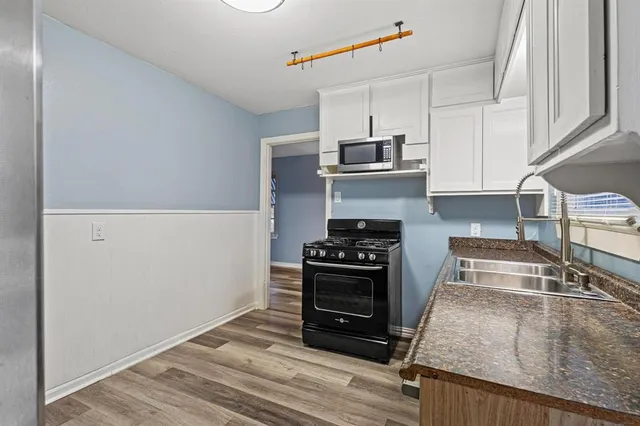 a kitchen with kitchen island a stove and a sink