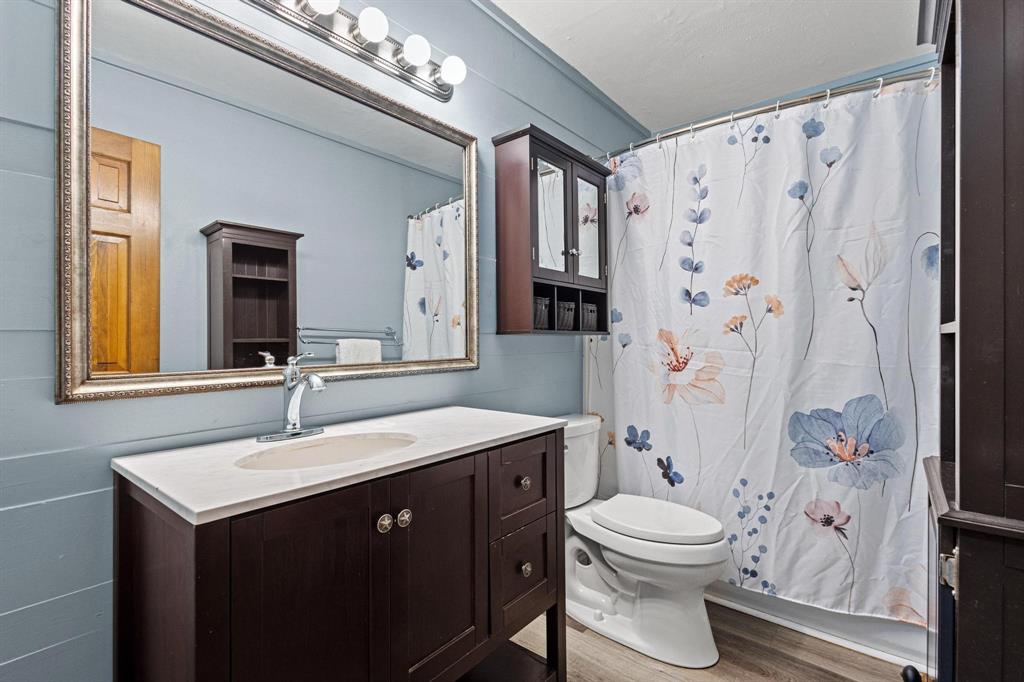 531 West Bullock Street Denison, TX 75020 - Photo 19 of 28 a bathroom with a sink a toilet and a mirror