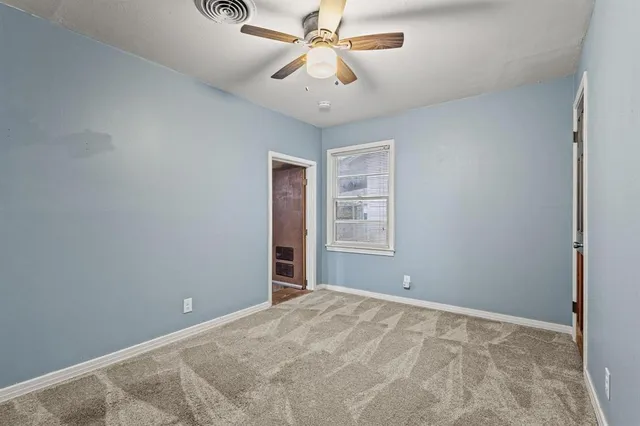 a view of a room with a ceiling fan and a window