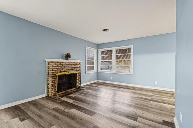 a view of an empty room with a fireplace and a window