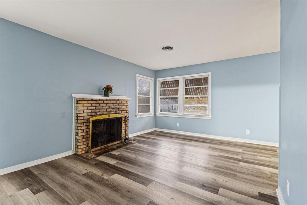 531 West Bullock Street Denison, TX 75020 - Photo 5 of 28 a view of an empty room with a fireplace and a window