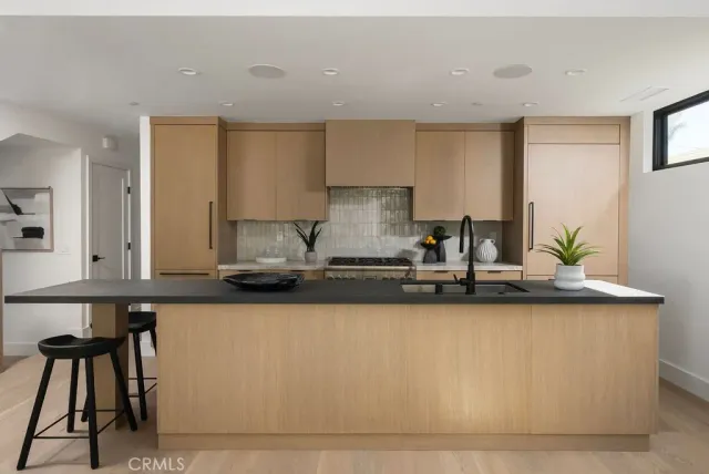 a kitchen with stainless steel appliances granite countertop a sink a stove and white cabinets