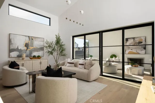 a living room with furniture a flat screen tv and a floor to ceiling window