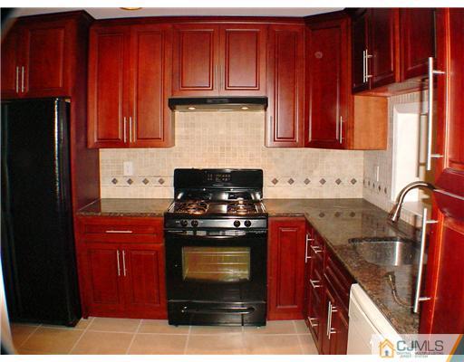 2202 Timber Oaks Road Edison, NJ 08820 - Photo 5 of 10 a kitchen with granite countertop stainless steel appliances wooden cabinets and a stove top oven