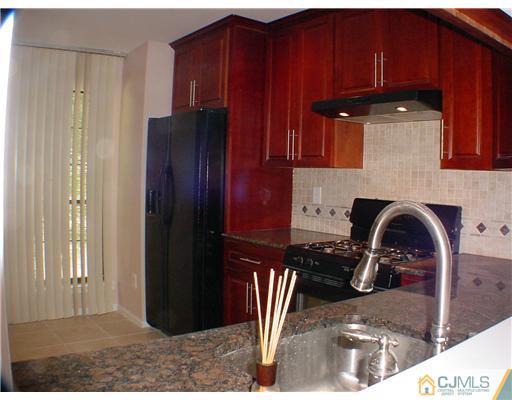 2202 Timber Oaks Road Edison, NJ 08820 - Photo 6 of 10 a kitchen with a refrigerator and a stove