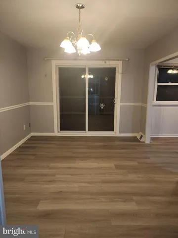 a view of a livingroom with a chandelier fan and wooden floor