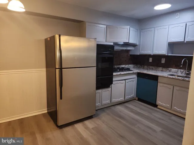 a kitchen with a refrigerator sink and cabinets