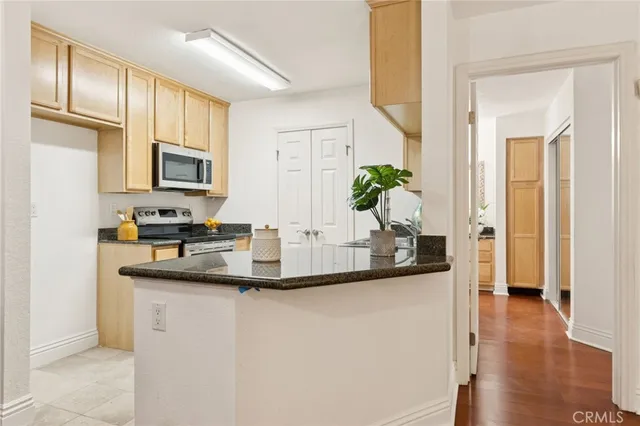 a kitchen with stainless steel appliances granite countertop a microwave a stove and white cabinets
