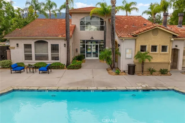 a group of lawn chairs sitting under a large pool with lawn chairs under an umbrella