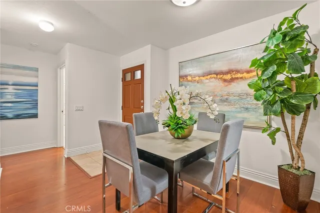 a dining room with furniture potted plants and wooden floor