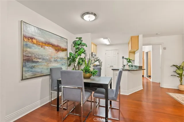a dining room with furniture potted plants and wooden floor