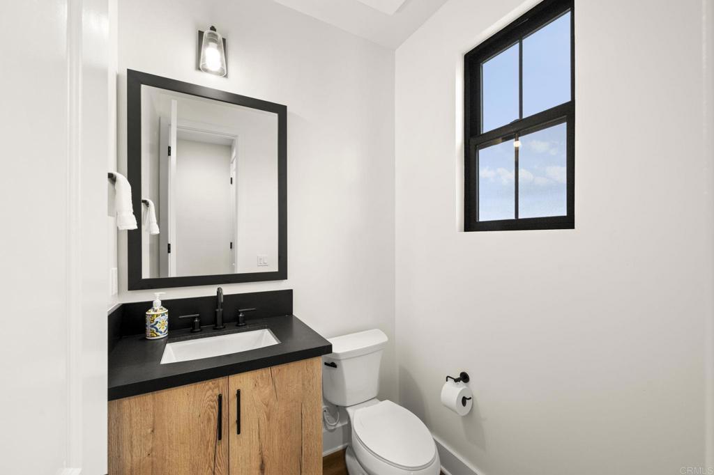 1303 Bergamo Encinitas, CA 92024 - Photo 6 of 21 a bathroom with a toilet sink vanity and mirror