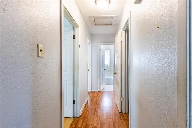 a view of a hallway with wooden floor and staircase
