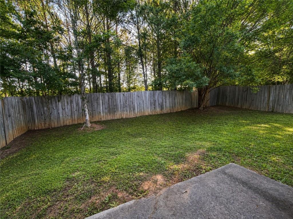 6936 Red Bone Way Stonecrest, GA 30038 - Photo 16 of 17 a view of a backyard with a large tree and wooden fence