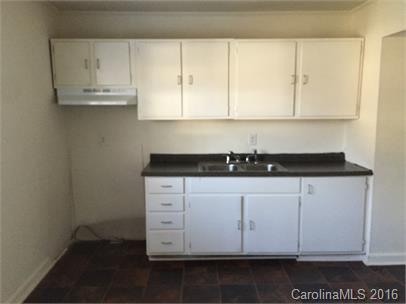 357 Freedom Street Southwest, Unit 2D Concord, NC 28025 - Photo 5 of 5 a kitchen with granite countertop white cabinets and sink