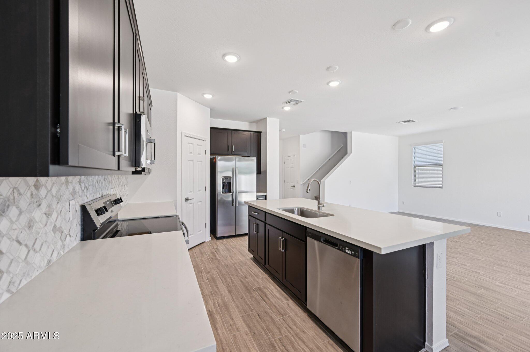 5535 South 240th Lane Buckeye, AZ 85326 - Photo 13 of 57 a kitchen with stainless steel appliances granite countertop a sink a stove and a refrigerator