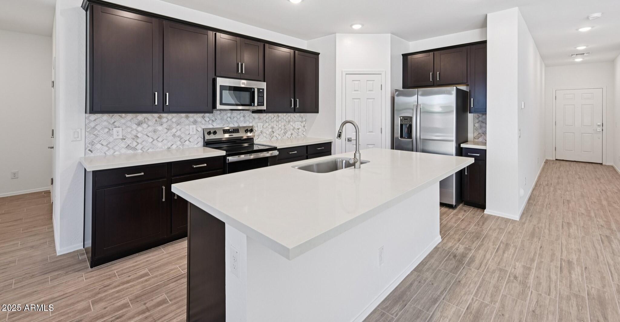 5535 South 240th Lane Buckeye, AZ 85326 - Photo 51 of 57 a kitchen with a sink a microwave a refrigerator and cabinets