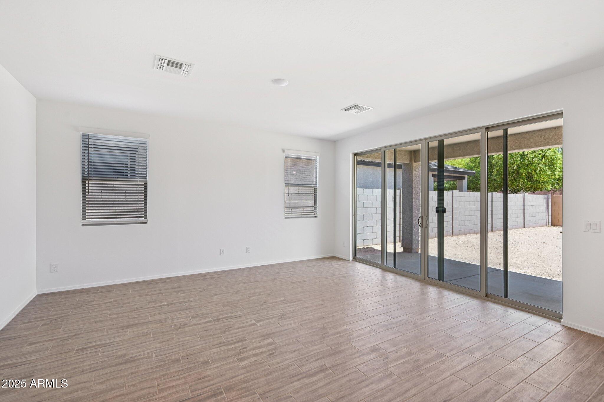 5535 South 240th Lane Buckeye, AZ 85326 - Photo 6 of 57 a view of an empty room with wooden floor and a window
