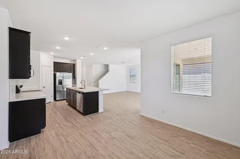 a large kitchen with stainless steel appliances a large counter top a stove and a refrigerator