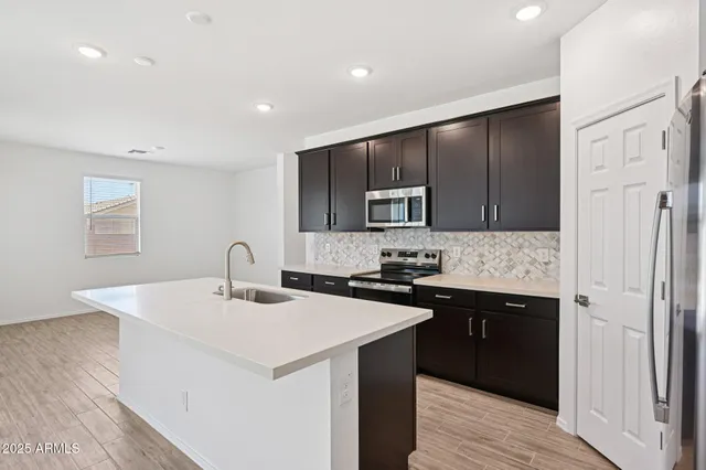 a kitchen with a sink a microwave a refrigerator and cabinets