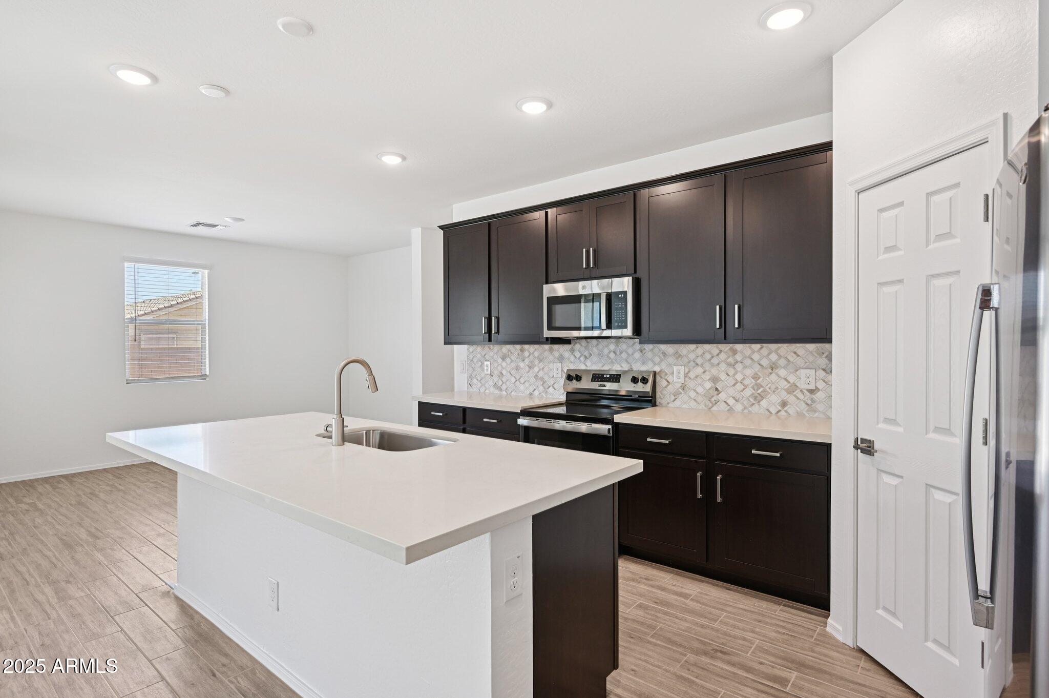 5535 South 240th Lane Buckeye, AZ 85326 - Photo 10 of 57 a kitchen with a sink a stove a refrigerator and a refrigerator