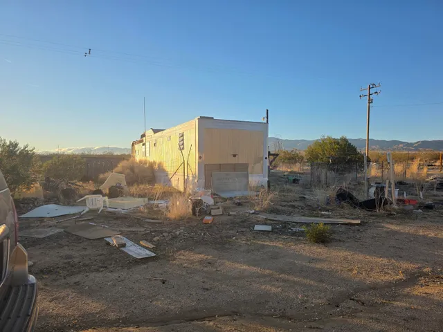 a view of a dry yard with wooden fence
