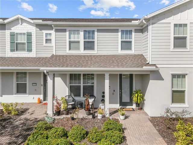 a front view of a house with outdoor seating and a potted plant