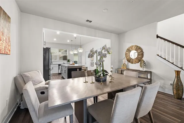a large kitchen with a table chairs stainless steel appliances and cabinets