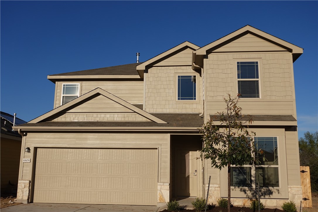 a view of a house with wooden fence