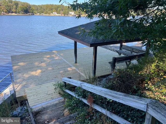 a wooden bench sitting in backside of a house with wooden fence
