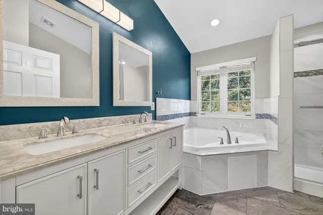 a bathroom with a sink double vanity granite and a large mirror