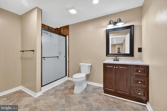 a bathroom with a toilet sink vanity and mirror