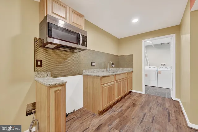 a kitchen with a sink a microwave and cabinets