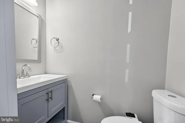 a bathroom with a toilet sink vanity and mirror