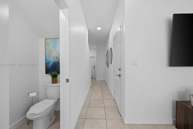 a view of a white house in front of a big yard with large trees