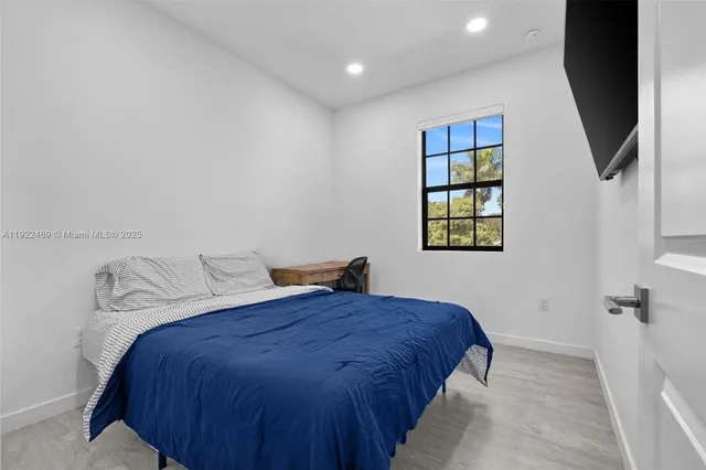 a bedroom with a bed and a flat screen tv