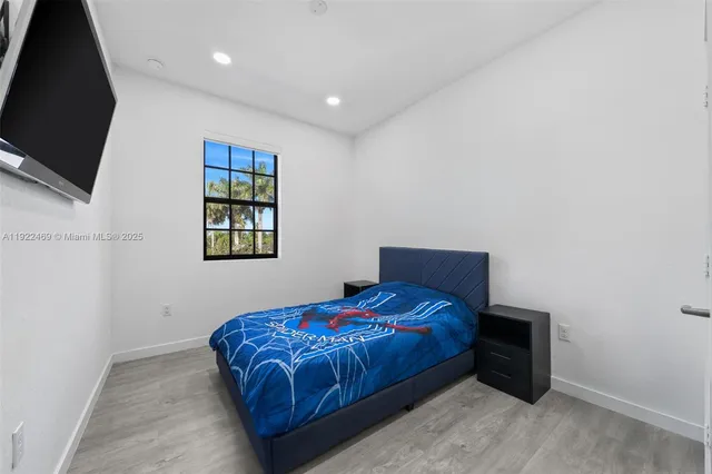 a bedroom with a bed and a flat screen tv