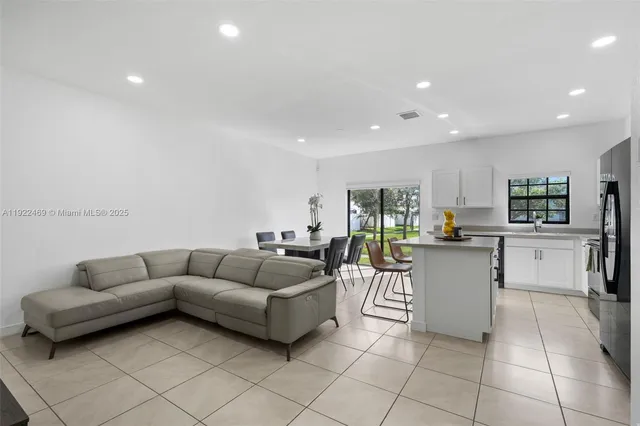 a living room with furniture and kitchen view