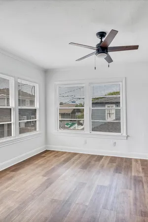 a view of an empty room with a window and wooden floor