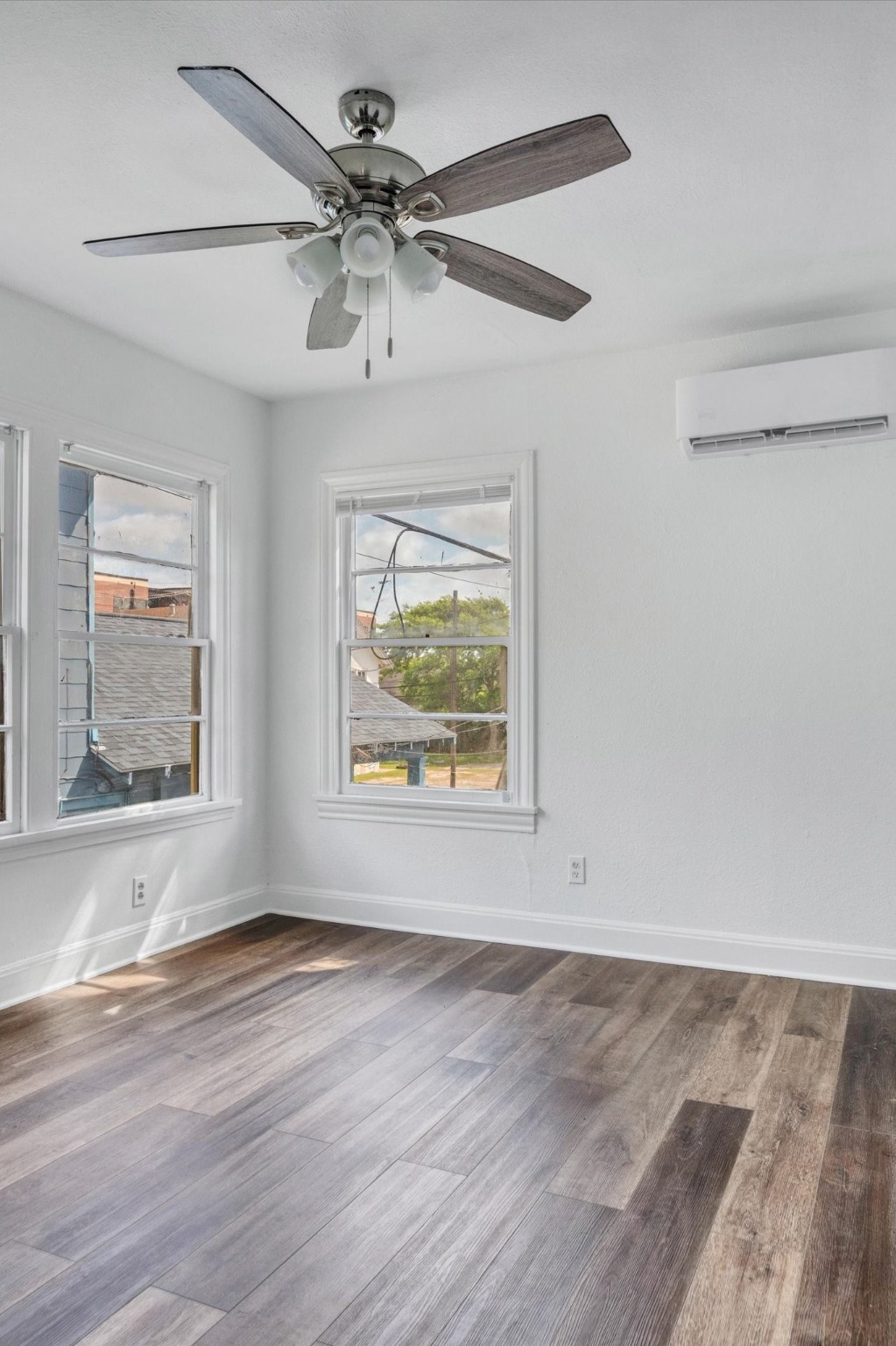 4006 Avenue R 1/2 Rear Galveston, TX 77550 - Photo 19 of 26 an empty room with wooden floor ceiling fan and windows