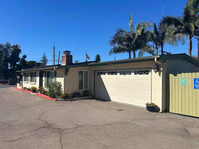a view of a house with a yard and potted plants
