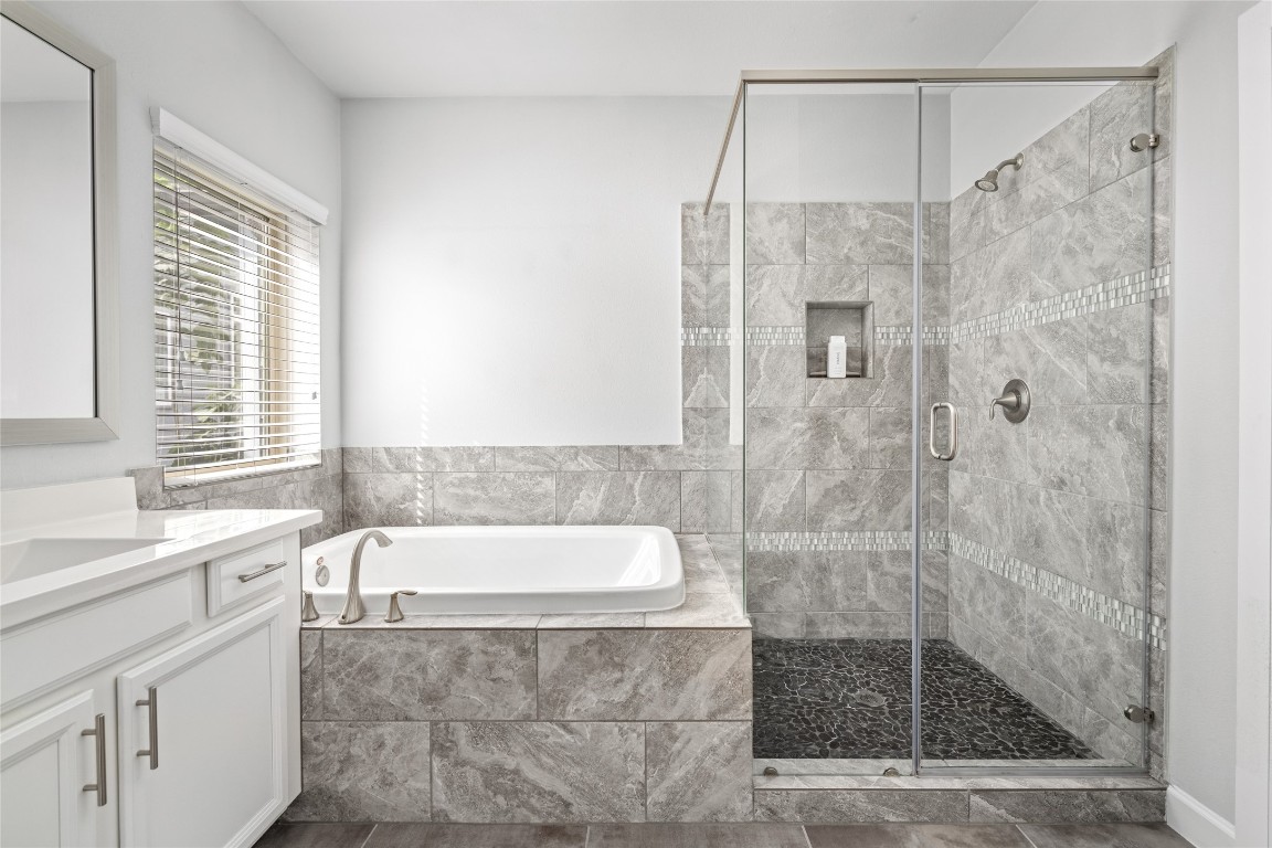 8923 Highgate Lane Houston, TX 77080 - Photo 13 of 23 The primary bathroom also offers a large soaking tub and a glass-enclosed walk-in shower.