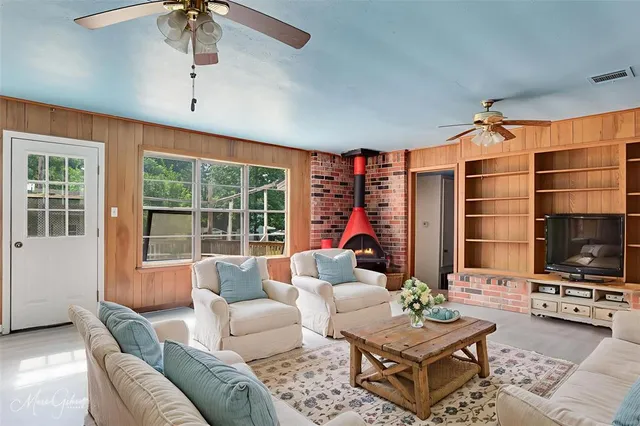 a living room with furniture a flat screen tv and a large window