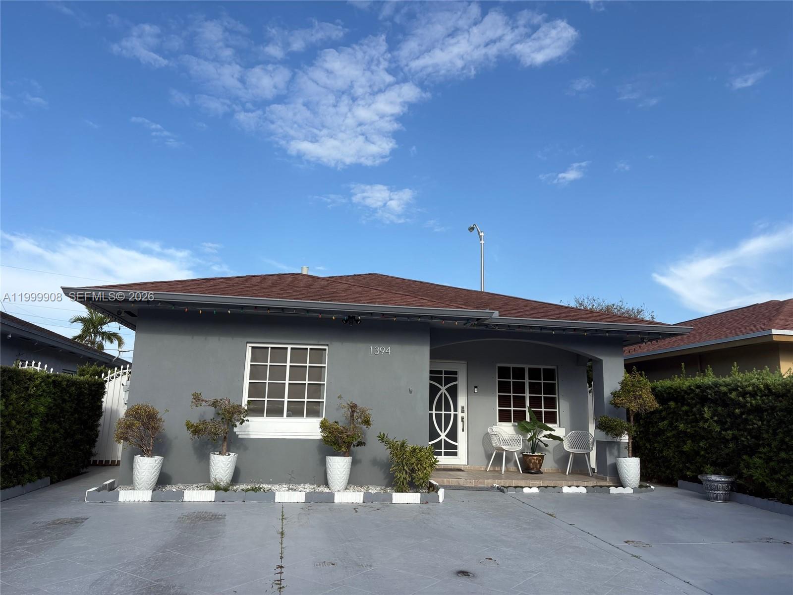 1394 West 30th Street Hialeah, FL 33012 - Photo 2 of 21 a front view of a house with outdoor seating