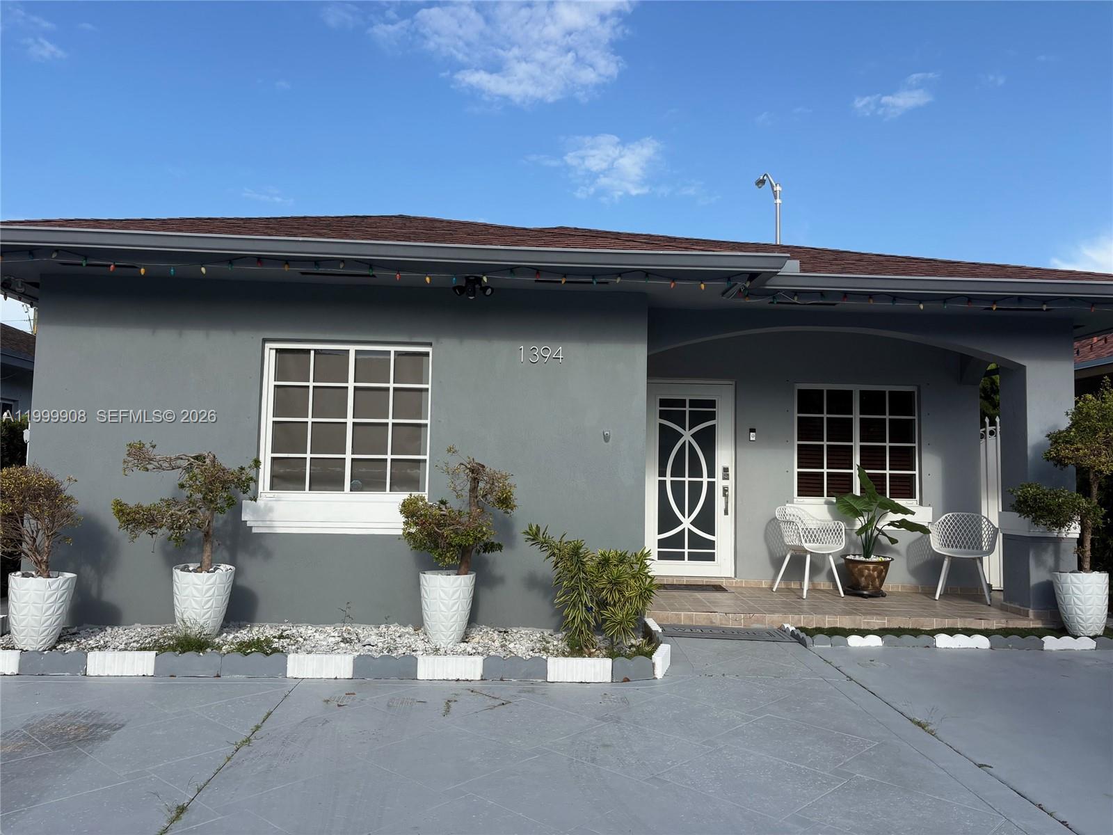 1394 West 30th Street Hialeah, FL 33012 - Photo 4 of 21 a front view of a house with outdoor seating and a garage