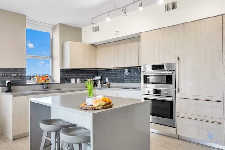 4010 South Ocean Drive, Unit R708 Hollywood, FL 33019 - Photo 12 of 30 a kitchen with stainless steel appliances a stove a sink and a refrigerator