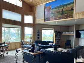 1940 East Shore Road St. Charles, ID 83272 - Photo 22 of 64 Living area with wooden walls, a vaulted wood ceiling, plenty of natural light, and carpet