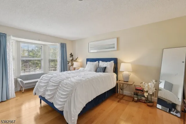 a bedroom with a bed and a flat tv screen on dresser